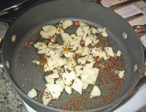 Potato pieces with spices braising in oil
